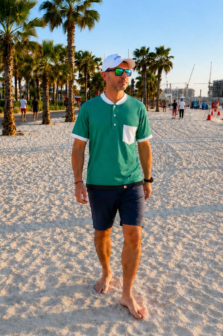 Man standing on a sandy beach with palm trees and a clear sky