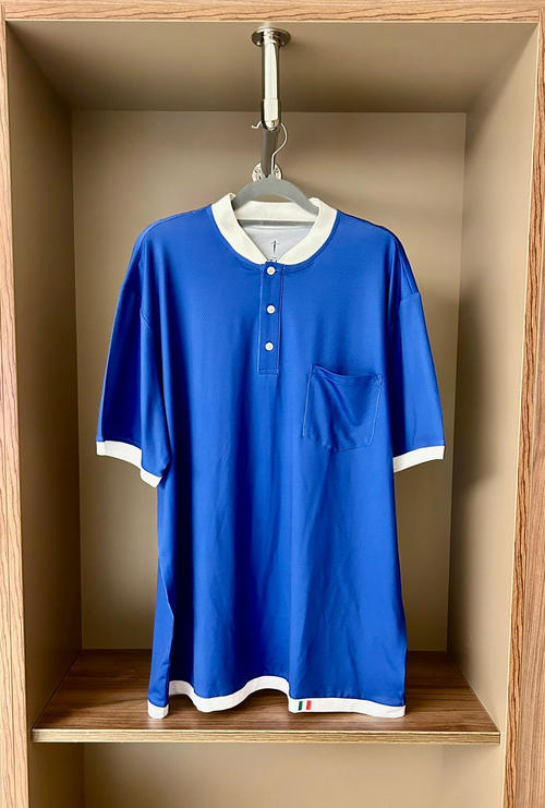 Blue shirt with white trim hanging in a wooden closet.
