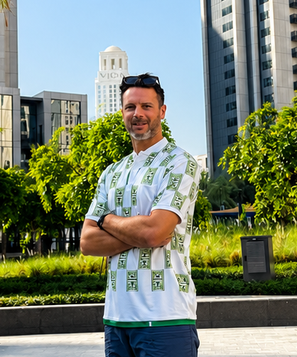 Man standing in a modern urban park with palm trees and tall buildings in the background