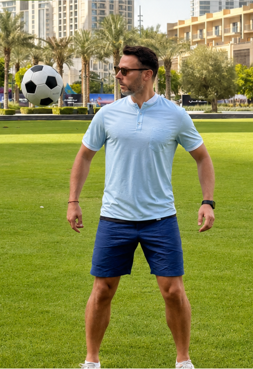 Man standing on a grassy field with a soccer ball in the background